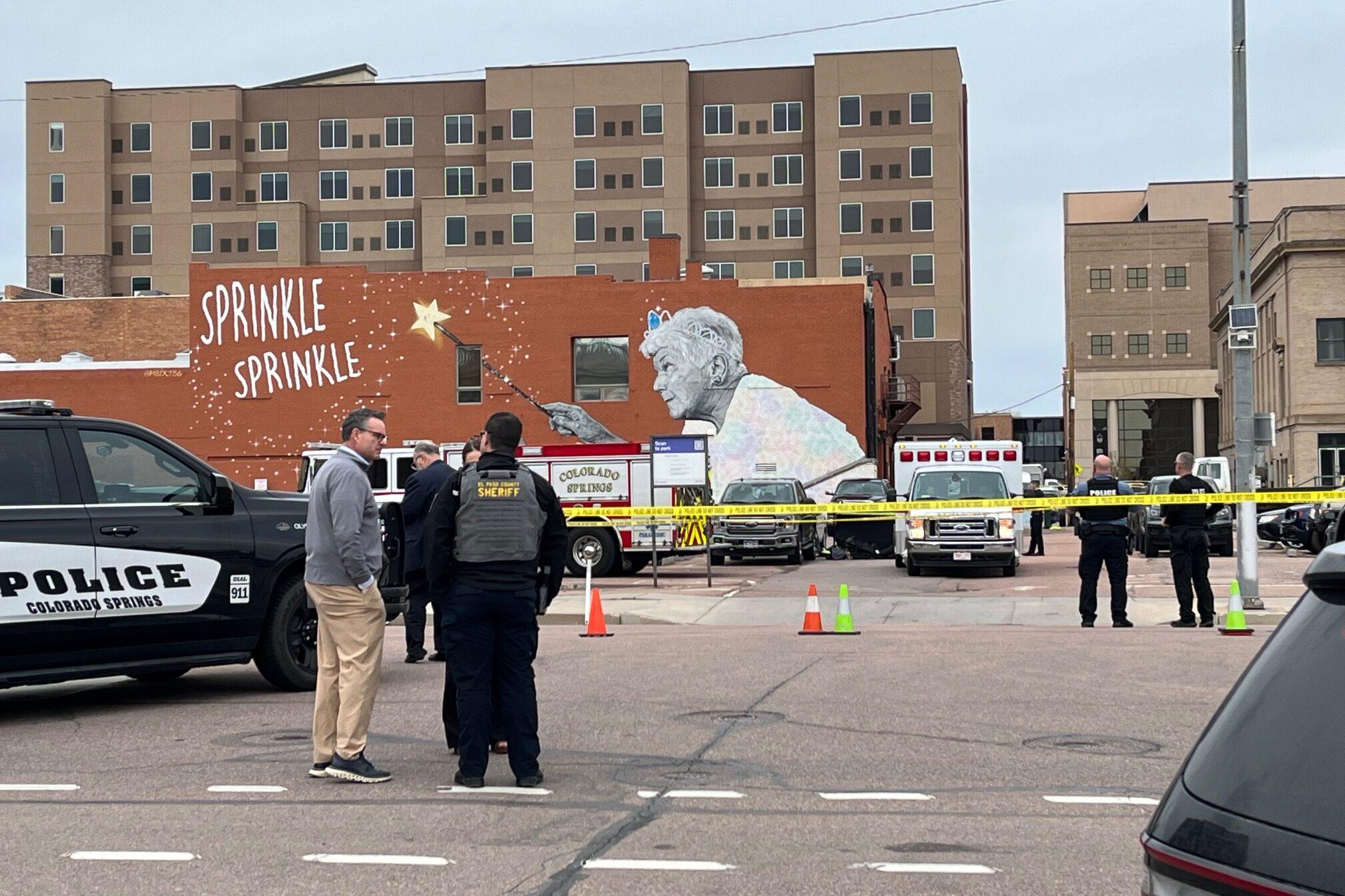 People standing outside with parked cars